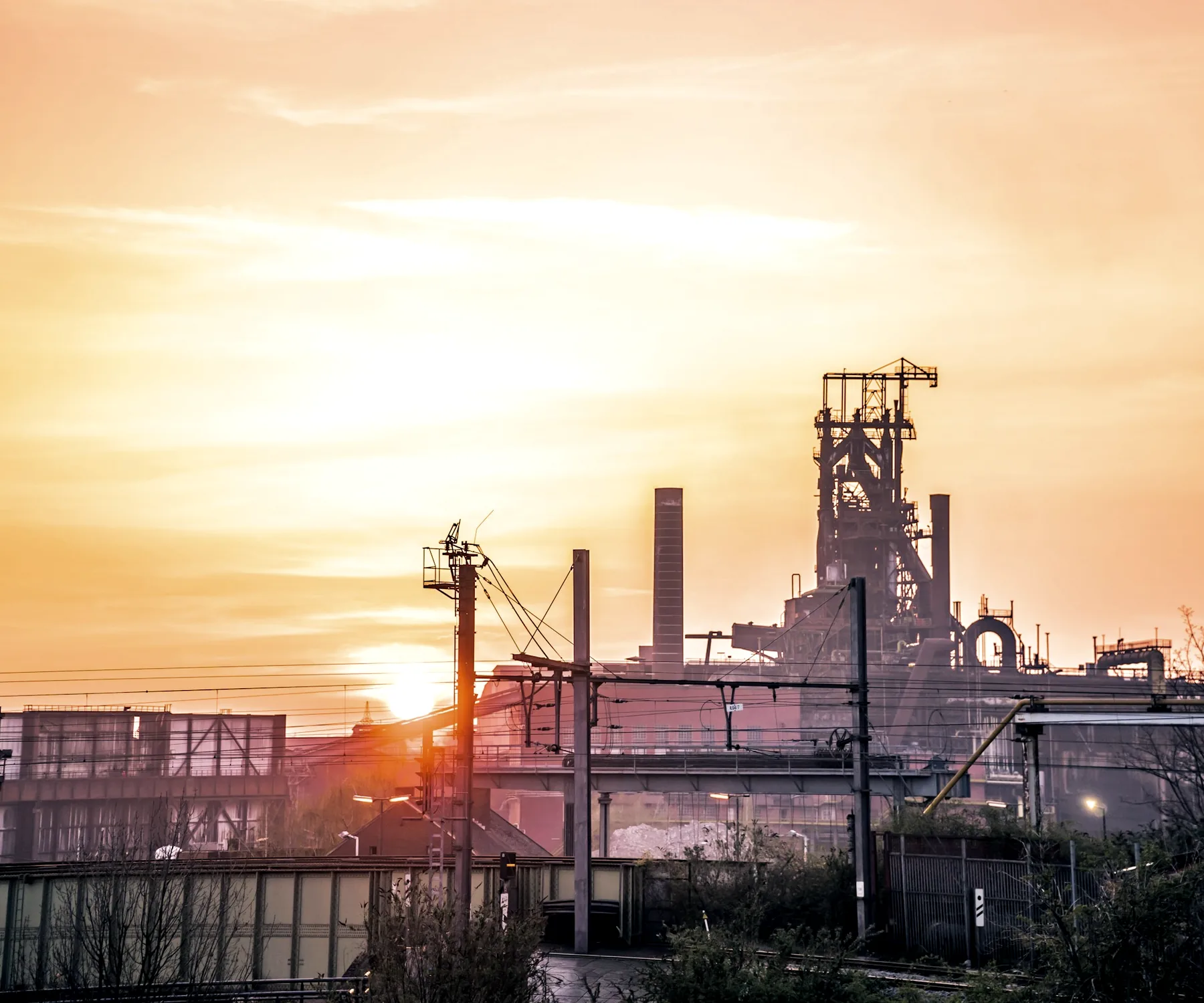 Industrial processing plant silhouetted against a sunset sky